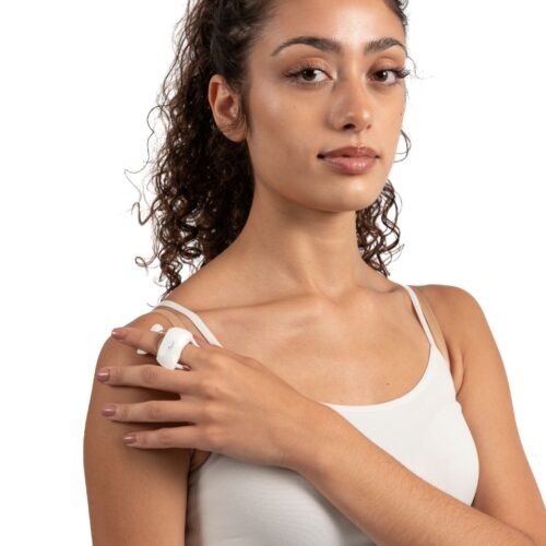 Tutore a molla per dito indossato dalla modella su mano destra appoggiata su spalla sinistra.